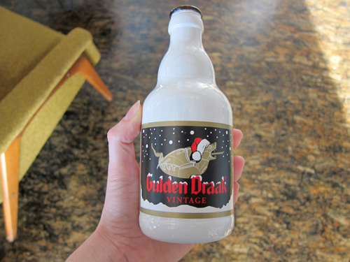Gulden Draak Vintage beer. White coated beer bottle with a golden pig/seal/submarine animal catching snowflakes on its tongue.