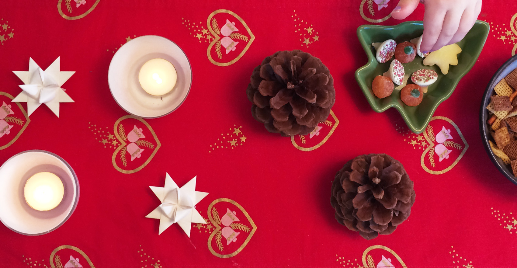 red table cloth with Danish christmas start and pine cone decorations. And chex mix.