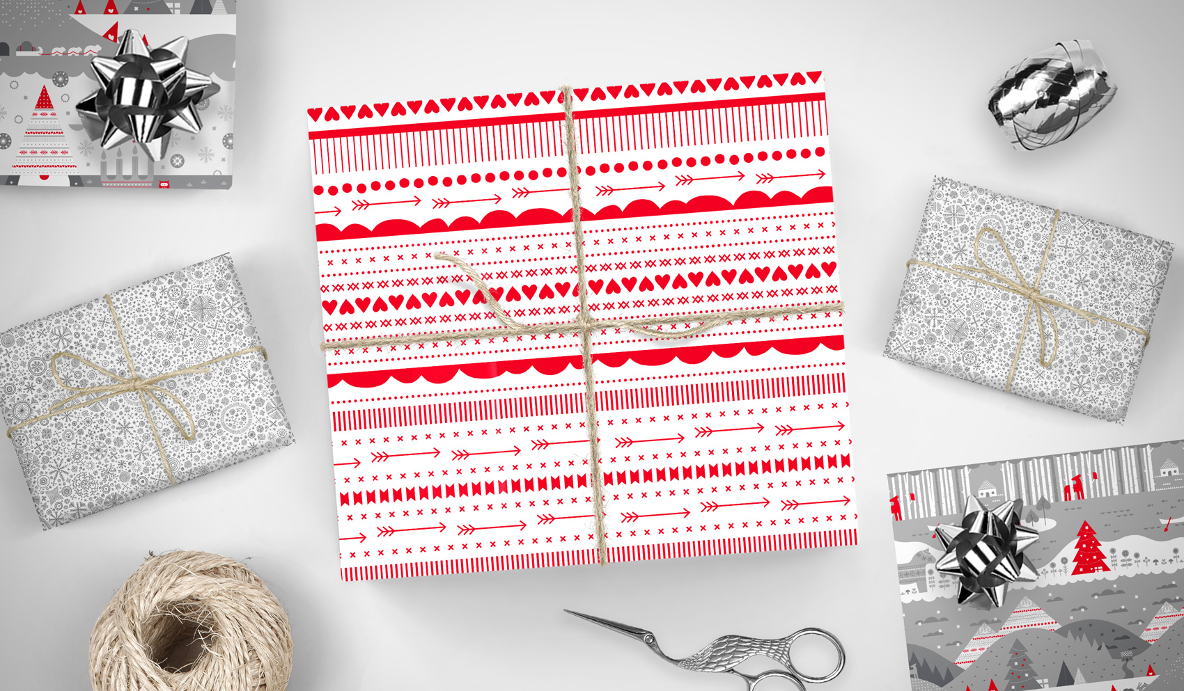 Gift wrap patterns on presents: red ribbons, silver snowflakes and tonal gray gnome villages.